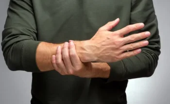 شاب يعاني من تغير في لون جلد مفاصل أصابع اليد