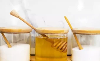مائدة تحتوي على برطمانات من العسل والسكر