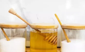 مائدة تحتوي على برطمانات من العسل والسكر